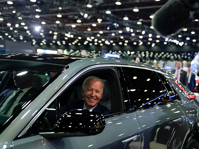 President Joe Biden drives a Cadillac Lyriq through the showroom during a tour at the Detroit Auto Show, Sept. 14, 2022, in Detroit. Ratcheting up his criticism of the Biden administration, Democratic Sen. Joe Manchin introduced legislation Wednesday to delay new tax credits for electric vehicles, a key feature of …