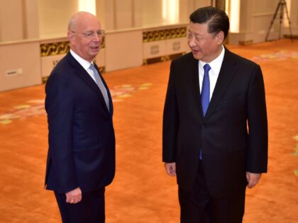 World Economic Forum head Klaus Schwab (L) is welcomed by Chinese President Xi Jinping (R)