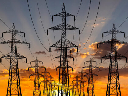 High voltage towers at sunset background. Power lines against the sky - stock photo