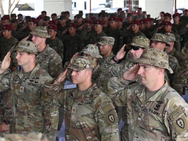 Philippine and US army soldiers salute as their national anthems are played during the ope