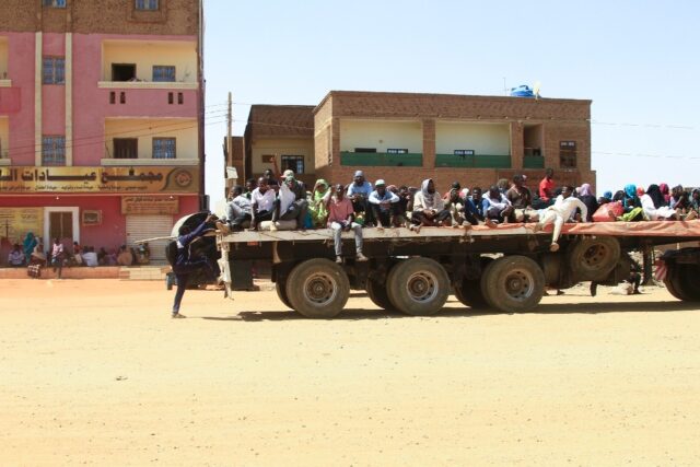 Civilians fleeing street battles on the back of a truck in southern Khartoum