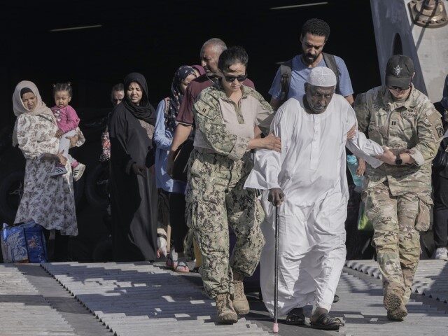Sudanese evacuee, Mohammed Abdel Rahman, 78, is helped by US naval doctors as he disembark