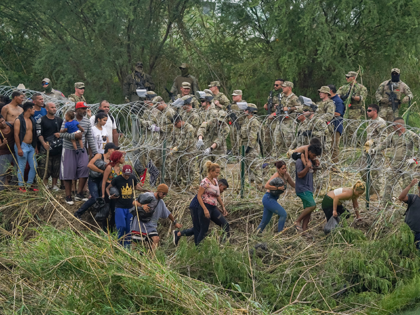Texas National Guardsmen reinforce a stretch of razor wire as migrants try to cross into t