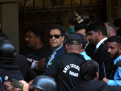 Pakistan's former Prime Minister Imran Khan, center, is escorted by security officials as he arrive to appear in a court, in Islamabad, Pakistan, Friday, May 12, 2023. A high court in Islamabad has granted Khan a two-week reprieve from arrest in a graft case and granted him bail on the …