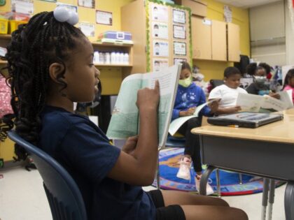 Learning to Read Explainer FILE - A third-grade student reads to the rest of her class at Beecher Hills Elementary School on Aug. 19, 2022, in Atlanta. For decades, there has been a clash between two schools of thought on how to best teach children to read, with passionate backers …