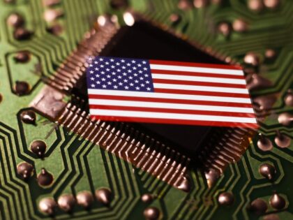 Microchip and flag of United States displayed on a phone screen are seen in this multiple exposure illustration photo taken in Krakow, Poland on April 12, 2023.