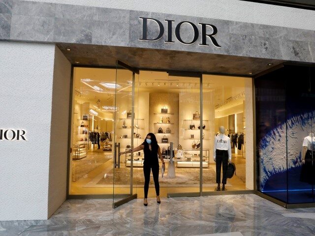 An employee wears a protective mask while opening a Dior store at the Shops & Restaura