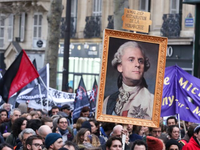 A protestor holds a portrait of the President Emmanuel Macron dressed as a king of France during a demonstration at the place de la Republique, in Paris, on December 17, 2019, to protest against French government's plan to overhaul the country's retirement system, as part of a national general strike …