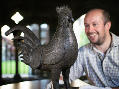 Archivist Robert Athol with a bronze statue of a cockerel called The Okukor, one of the Be