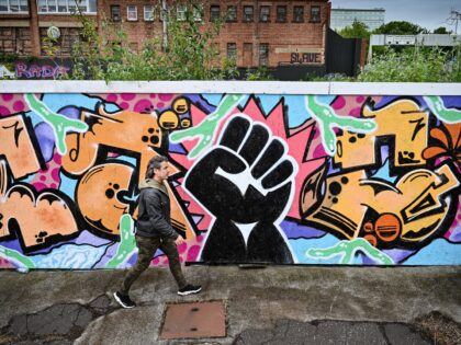 GLASGOW, SCOTLAND - JUNE 23: A man walks past a black lives matter mural by artist Boss City Taio on June 23, 2020 in Glasgow, Scotland. Black Lives Matter protests are continuing across the UK following the death of African American George Floyd at the hands of police officers in …