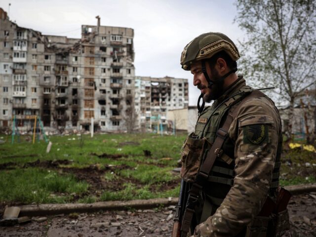 EDITORS NOTE: Graphic content / A Ukrainian serviceman walks near a residential building d