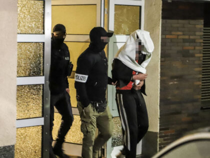 Police guide an arrested person out of a residential house in Hagen, western Germany, on May 3, 2023 as part of a "wide-scale" operation against the notorious Italian 'Ndrangheta mafia across Europe. - In Germany, hundreds of officers carried out raids in five parts of the country, regional prosecutors said …
