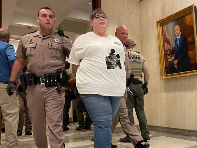 An unidentified protester is arrested and escorted out of Gov. Ron DeSantis&apos; office suite at the Florida Capitol on Wednesday, May 3, 2023. (Ana Ceballos/Miami Herald/Tribune News Service via Getty Images)