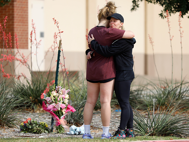 MacKenzie Bates (L), 17, of Allen, Texas, embraces her mother Rochelle where flowers were