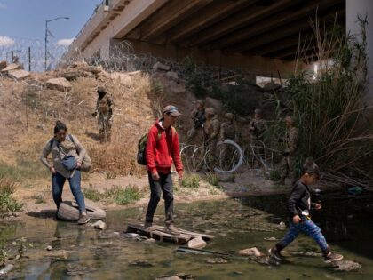 CIUDAD JUÁREZ, MEXICO - MAY 13: Migrants cross back over the Rio Grande after being told by Texas National Guard members that they had to leave the area where they were gathered underneath the Zaragoza Bridge with the hopes of turning themselves in to seek asylum in the United States …
