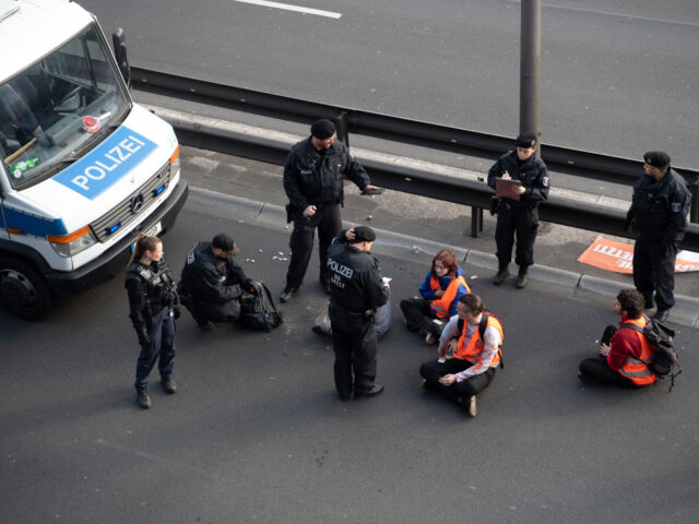 19 May 2023, Berlin: Police officers stand by some activists during a blockade by the Last