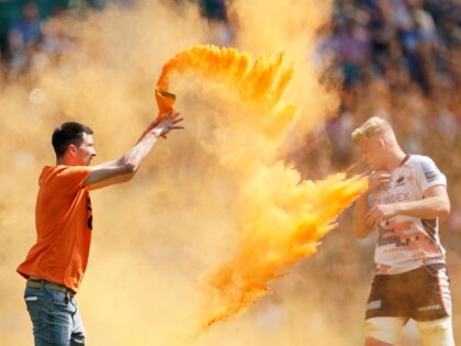 A Just Stop Oil protester throws orange powder on the pitch during the Gallagher Premiersh