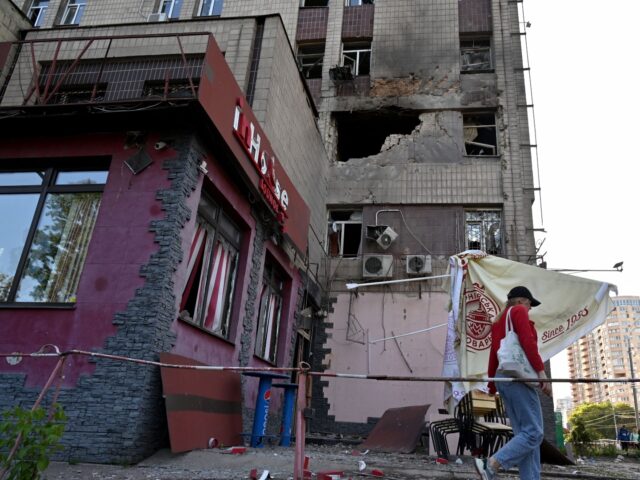 A local resident walks past a partially destroyed residential building after a massive Rus