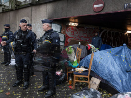 PARIS, FRANCE - NOVEMBER 28: Police stand in front of tents during a protest in solidarity with the residents of this temporary camp for migrants where some 150 people are living under a motorway, on November 28, 2021, in Paris, France. As the cold of winter sets in, over 1000 …