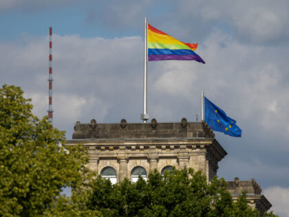BERLIN, GERMANY - JULY 23: A rainbow flag, symbol of the queer community, flys over the Reichstag, seat of the Bundestag, which was hoisted for the first time by the Bundestag, while people participate in the annual Christopher Street Day parade and dance in a procession through the city on …