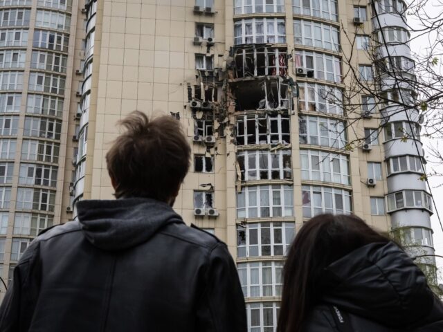KYIV, UKRAINE – MAY 8: People look at a residential building damaged by drones debris on