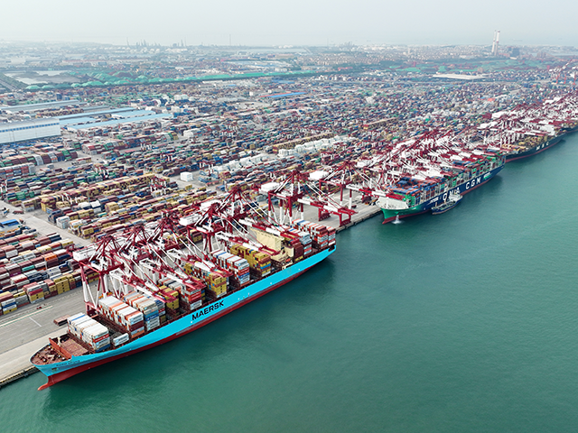 Aerial view of shipping containers sitting stacked at Qingdao Qianwan Container Terminal o