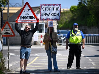 PORTLAND, ENGLAND - MAY 13: Protesters and port security are seen during a rally against the UK government's plans to house 500 migrants on a barge off the Dorset coast on May 13, 2023 in Portland, England. Organisers, Stand Up To Racism Dorset, have said the march and protest at …
