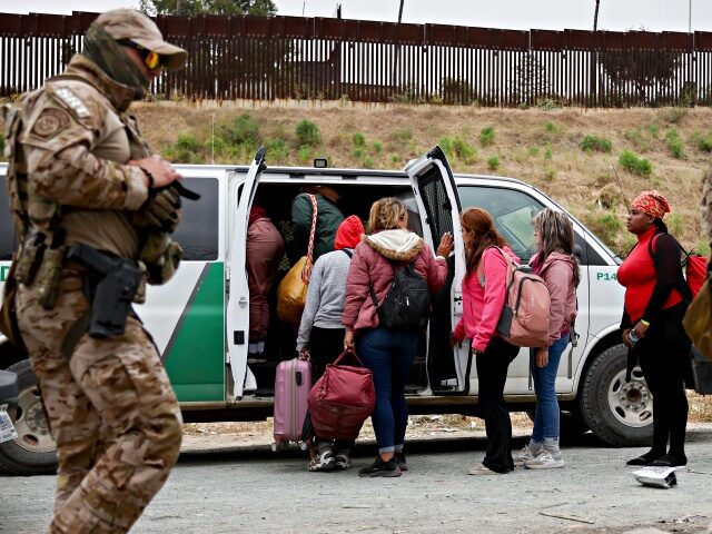 SAN DIEGO, CALIFORNIA - MAY 13: Customs and Border Protection officers walk as immigrants