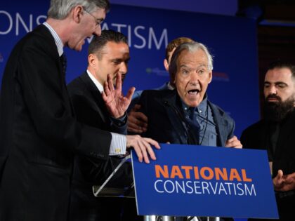 LONDON, ENGLAND - MAY 15: A critic is escorted from the stage after interrupting a keynote speech by Conservative MP Jacob Rees-Mogg (L) during the National Conservatism conference at The Emmanuel Centre on May 15, 2023 in London, England. Traditionalist conservatives gather for their annual conference in Central London. National …
