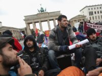 BERLIN, GERMANY - OCTOBER 17: Refugees from Iraq, Iran and Afghanistan keep warm on the 8th day of a hunger strike in front of the Brandenburg Gate on October 17, 2013 in Berlin, Germany. 28 refugees, some of whom have been in Germany for as long as seven years waiting for their asylum applications to be processed, are participating and many have refused to drink any liquids since October 11, and say they will do so until the German government makes a firm commitment to helping them. About a dozen of the refugees have already been hospitalized, and most have come back to participate further in the hunger strike. (Photo by Sean Gallup/Getty Images)
