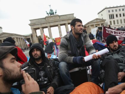 BERLIN, GERMANY - OCTOBER 17: Refugees from Iraq, Iran and Afghanistan keep warm on the 8th day of a hunger strike in front of the Brandenburg Gate on October 17, 2013 in Berlin, Germany. 28 refugees, some of whom have been in Germany for as long as seven years waiting …