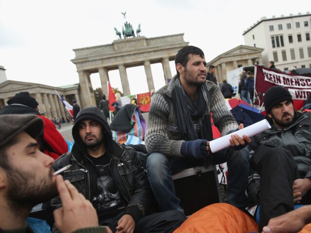 BERLIN, GERMANY - OCTOBER 17: Refugees from Iraq, Iran and Afghanistan keep warm on the 8t