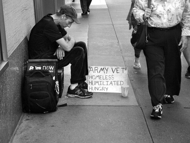 NEW YORK, NEW YORK - SEPTEMBER 22, 2017: A man sits on a busy New York City sidewalk with a sign declaring he is a homeless military veteran. (Photo by Robert Alexander/Getty Images)