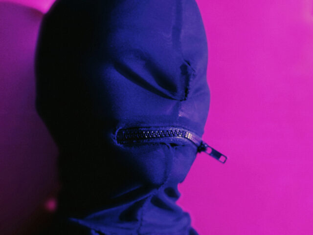 Person wearing zippered fetish mask, portrait