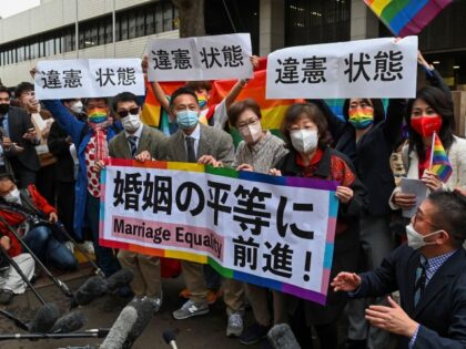 Plaintiffs and supporters react in front of the Tokyo District Court in Tokyo on November 30, 2022, following a ruling in a lawsuit filed by same-sex couples seeking damages from the government. - Japan's lack of legal protections for same-sex partners is an "unconstitutional situation", a Tokyo court ruled November …