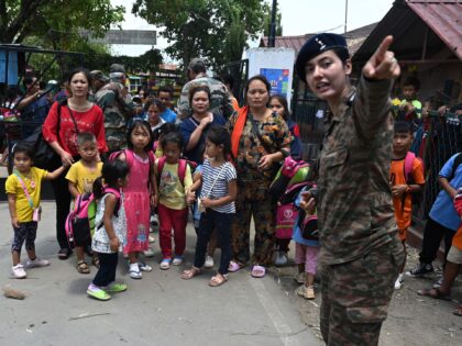 Anti-Christian An Indian army personnel gestures as children evacuated by the Indian army