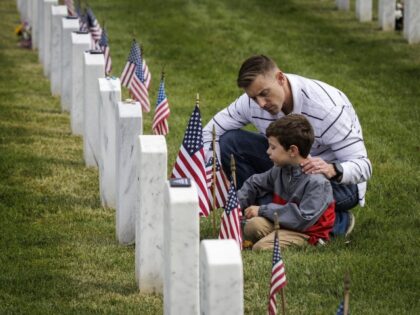 Brad Fromm talks to his son, Tyler, at the final resting place of a fallen loved one in Arlington National Cemetery on Memorial Day, May 29, 2023, in Arlington, Virginia. The United States celebrates Memorial Day each year to honor those who have died while serving in the armed forces. …