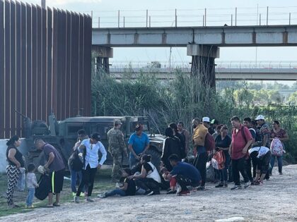 A group of migrants walk around the end of the Texas-built border wall to surrender to law enforcement. (Randy Clark/Breitbart Texas)