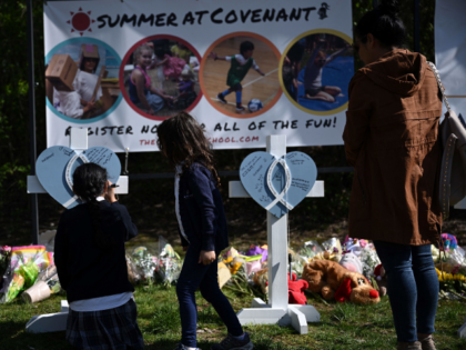 People pay their respects at a makeshift memorial for victims at the Covenant School building at the Covenant Presbyterian Church following a shooting, in Nashville, Tennessee, on March 28, 2023. - A heavily armed former student killed three young children and three staff in what appeared to be a carefully …
