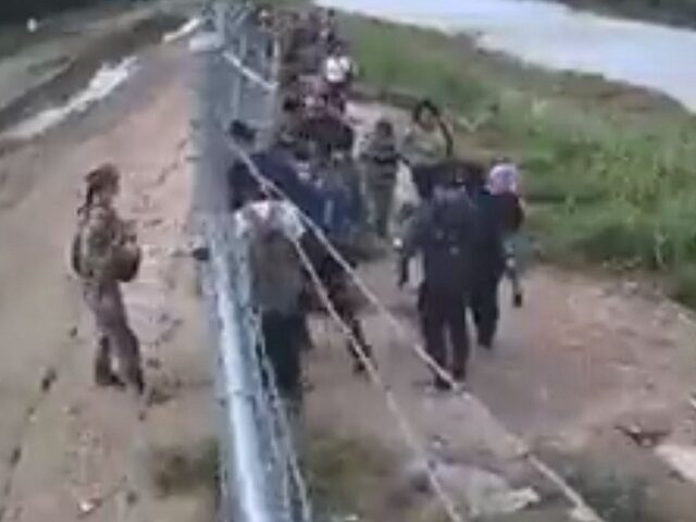 A government surveillance video shows a National Guard soldier opening a border gate for m