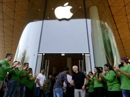 Tim Cook, chief executive officer of Apple Inc., center right, shakes hands with a customer during the opening of the new Apple BKC store in Mumbai, India, on Tuesday, April 18, 2023. Cook officially opened Apple Inc.'s first company-owned store in India, betting the iPhone maker's retail outlets will help …