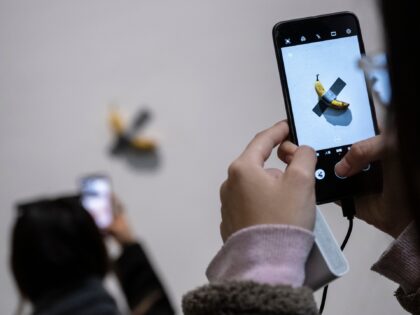 BEIJING, CHINA - NOVEMBER 28: Visitors take pictures of the work "Comedian" by Italian artist Maurizio Cattelan that is part of his exhibition "The Last Judgement'' at the UCCA Center for Contemporary Art on November 28, 2021 in Beijing, China. The show, which displays work from three decades of Cattelan" …