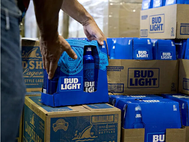 An employee adjusts bottles of Bud Light brand beer at an Anheuser-Busch InBev NV facility