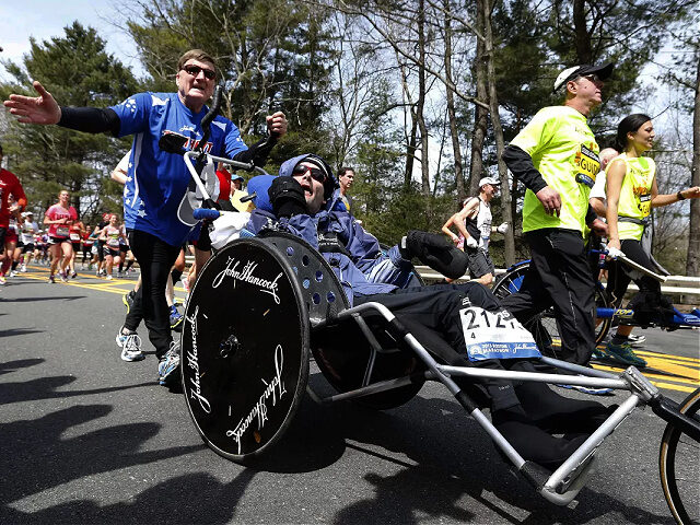 Rick Hoyt, center, is pushed by his father Dick, left, along the Boston Marathon course, A
