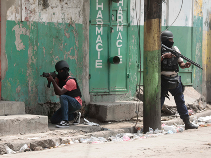 Police officers take cover during an anti-gang operation in the Portail neighborhood of Port-au-Prince, Haiti, Tuesday, April 25, 2023, a day after a mob in the Haitian capital pulled 13 suspected gang members from police custody at a traffic stop and beat and burned them to death with gasoline-soaked tires. …