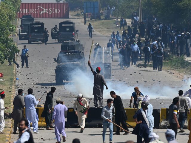 Police (back) use teargas to disperse Pakistan Tehreek-e-Insaf (PTI) party activists and supporters (foreground) of former Pakistan's Prime Minister Imran Khan during a protest against the arrest of their leader, in Islamabad on May 10, 2023. Khan will appear in a special court at the capital's police headquarters to answer …