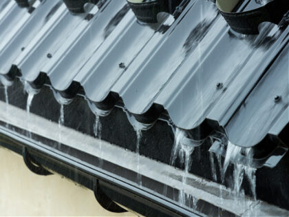 Rain water flowing down the roof of the roof into the gutter - stock photo