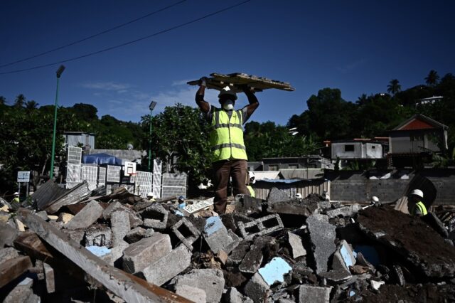 Diggers started destroying sheet-metal shacks in the slum in the Koungou area