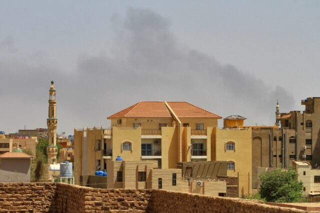 Smoke rises above buildings in Khartoum as fighting between the forces of two rival genera