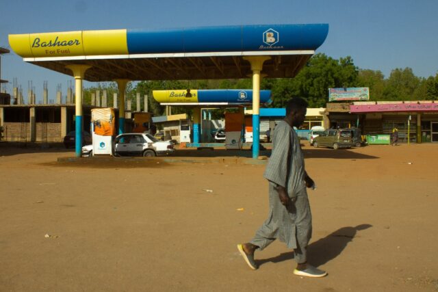 A man walks past a shuttered petrol station in Madani, southeast of the Sudanese capital K